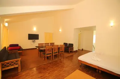 a living room with a table and a dining room at Tiger Hill Homestay in Ooty