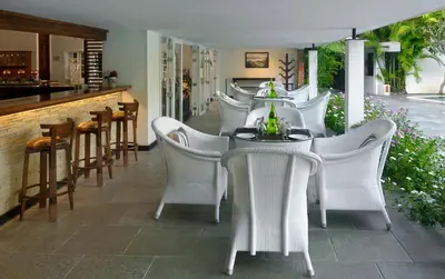 a group of white chairs and a table in a restaurant at Amanvana Spa Resort, Coorg in Kushālnagar