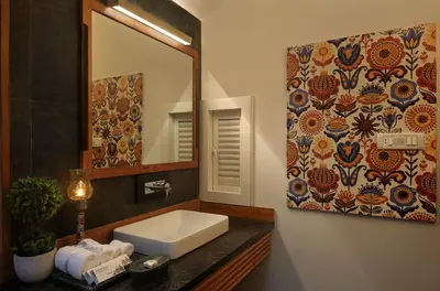 a bathroom with a sink and a mirror at Amanvana Spa Resort, Coorg in Kushālnagar