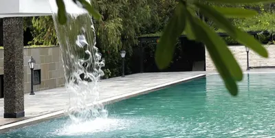 a water fountain in a swimming pool at Amanvana Spa Resort, Coorg in Kushālnagar