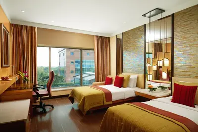 a hotel room with two beds and a window at Vivanta Coimbatore in Coimbatore