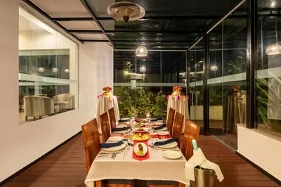 a dining room with a long table with chairs at Sterling Ooty Fern Hill in Ooty