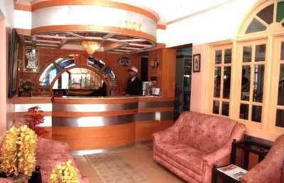 a lobby with a bar with a man standing at a counter at Hotel Silver Oak in Ooty