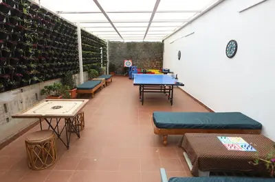 a room with tables and benches and plants at Delightz Inn in Ooty