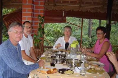 a group of people sitting at a table with food at The Four Seasons in Kalpetta