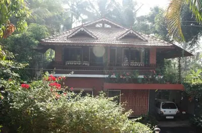 a house with a car parked in front of it at The Four Seasons in Kalpetta
