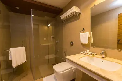 a bathroom with a toilet and a sink and a shower at Grand Plaza Suites in Kozhikode