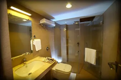 a bathroom with a toilet and a sink and a shower at Grand Plaza Suites in Kozhikode