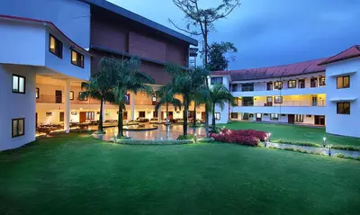 a courtyard of a building with a grass yard at Vythiri Village in Vythiri