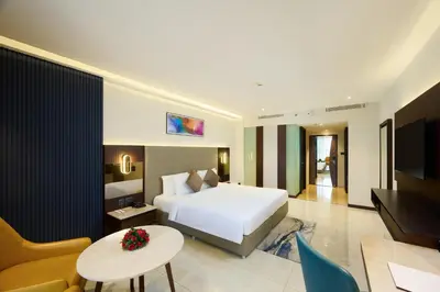 a hotel room with a bed and a living room at Flora Airport Hotel and Convention Centre Kochi in Nedumbassery