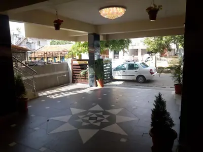 a garage with a car parked in a parking lot at Hotel Lovely Nest in Coimbatore