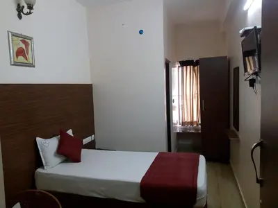 a hotel room with a bed with red pillows at Hotel Lovely Nest in Coimbatore