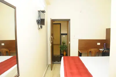 a room with a bed and a table and chairs at Hotel Lovely Nest in Coimbatore