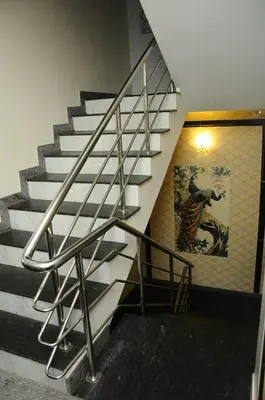 a metal staircase in a building with a painting on the wall at Hotel Lovely Nest in Coimbatore