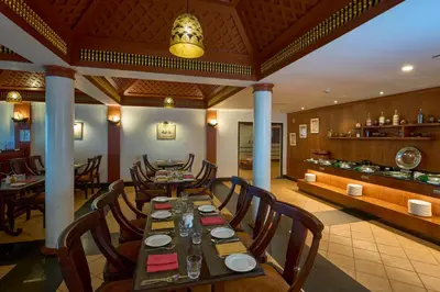 a dining room with a long table and chairs at The Raviz Kadavu, Kozhikode in Kozhikode