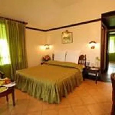 a bedroom with a large bed with green curtains at The Raviz Kadavu, Kozhikode in Kozhikode
