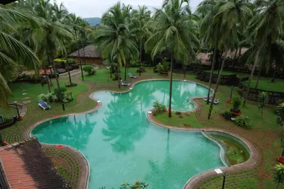 an overhead view of a swimming pool with palm trees at The Raviz Kadavu, Kozhikode in Kozhikode
