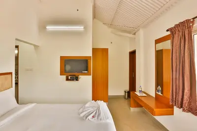a bedroom with a bed and a tv on the wall at Mystique stay resort in Kotagiri