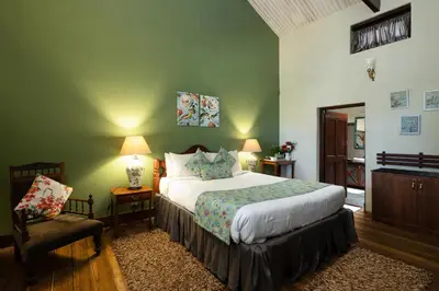 a bedroom with a large bed and a chair at King's Cliff in Ooty
