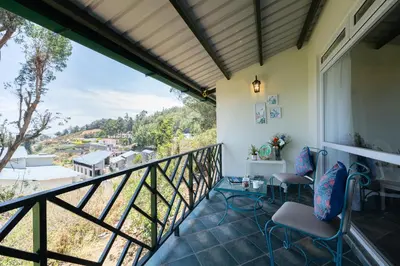 a balcony with chairs and a view at King's Cliff in Ooty
