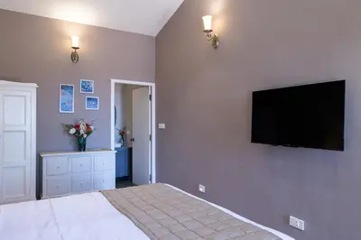 a bedroom with a bed and a flat screen tv on the wall at King's Cliff in Ooty