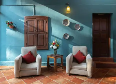 two chairs and a table with a vase of flowers at Sherlock in Ooty