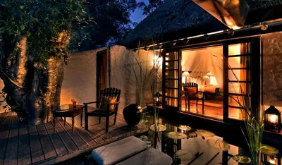 a patio with a table and chairs and a bedroom at Evolve Back Coorg in Siddapur