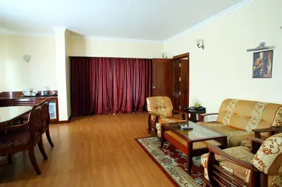 a living room with a couch and a table at Joys Palace Hotel in Trichūr