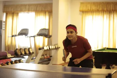 a man standing in front of a ping pong table at Joys Palace Hotel in Trichūr