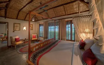 a bedroom with a large bed in a room at Evolve Back Kabini in Begūr