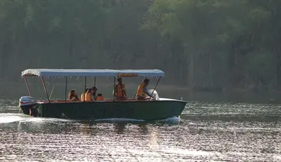 a group of people on a boat in the water at Evolve Back Kabini in Begūr