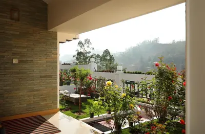 a balcony with a view of a garden at Elysium Garden in Munnar