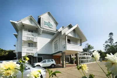 a building with a car parked in front of it at Elysium Garden in Munnar