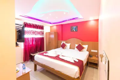 a bedroom with a large bed with red walls at Sree Comforts in Kushālnagar