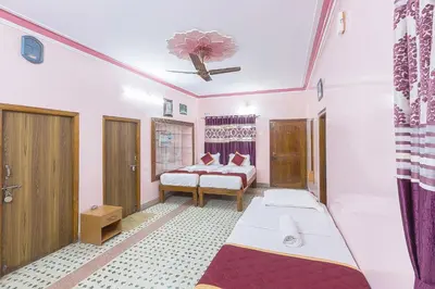 a bedroom with two beds and a ceiling at Sree Comforts in Kushālnagar