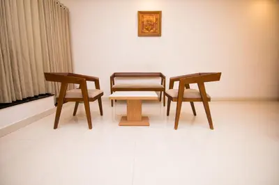 two chairs and a table in a room at Hotel Kapilavasthu in Palakkad