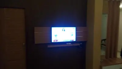 a television on a wall in a room at Hotel Kapilavasthu in Palakkad