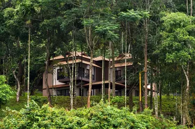 a building in the middle of a forest of trees at The Serenity Resort in Tariyod