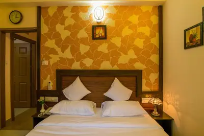 a bedroom with a bed with two white pillows at Blue Bell Cochin Airport Hotel in Nedumbassery