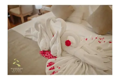 two white swans are making a heart on a bed at Whispering Waters in Malayāttūr