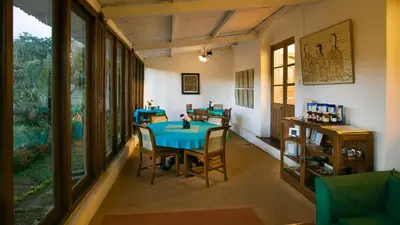 a dining room with a blue table and chairs at Neemrana's Wallwood Garden in Coonoor