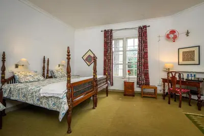 a bedroom with a bed and a window at Neemrana's Wallwood Garden in Coonoor