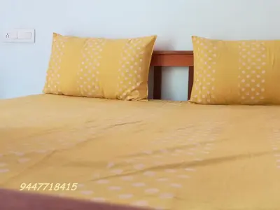 a bed with yellow sheets and two pillows at Kanthalloor Homestay Snow White Holiday Homes in Kanthalloor