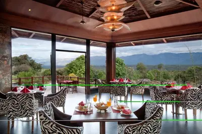 a restaurant with a view of the mountains at The Serai Bandipur in Bandipūr