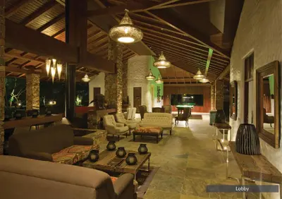 a large living room with couches and chairs and tables at The Serai Bandipur in Bandipūr