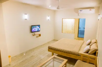 a bedroom with a bed and a tv on the wall at Rathna Square in Pollāchi