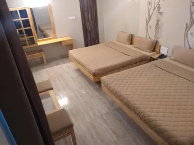 a small room with two beds and a mirror at Rathna Square in Pollāchi