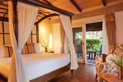 a bedroom with a bed and a balcony at The Serai Kabini in Begūr