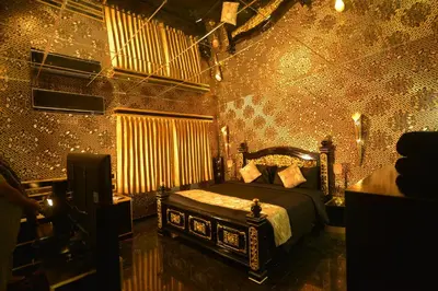 a bedroom with a bed in a room with gold wallpaper at Poppys Vista Hotel in Thirumurugan Poondi