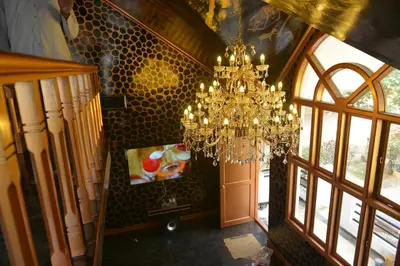 a chandelier is hanging in a room with a door at Poppys Vista Hotel in Thirumurugan Poondi